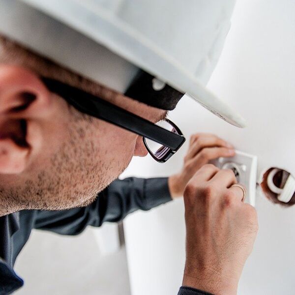 Electrician installing wiring in a wall